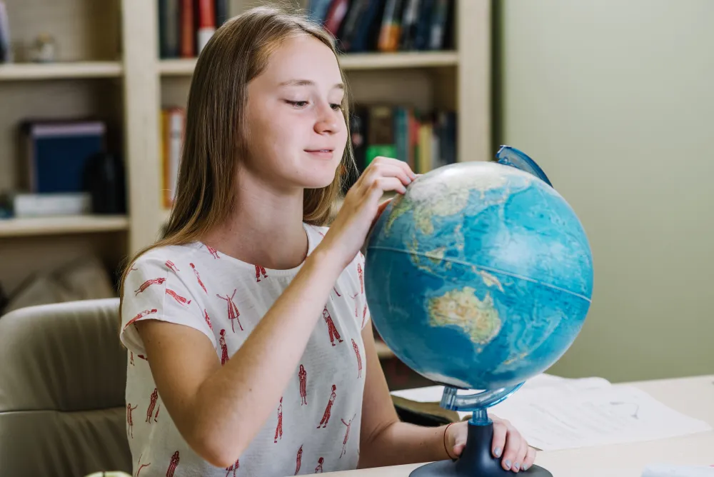 Schüler lernt mit einem Globus Geografie